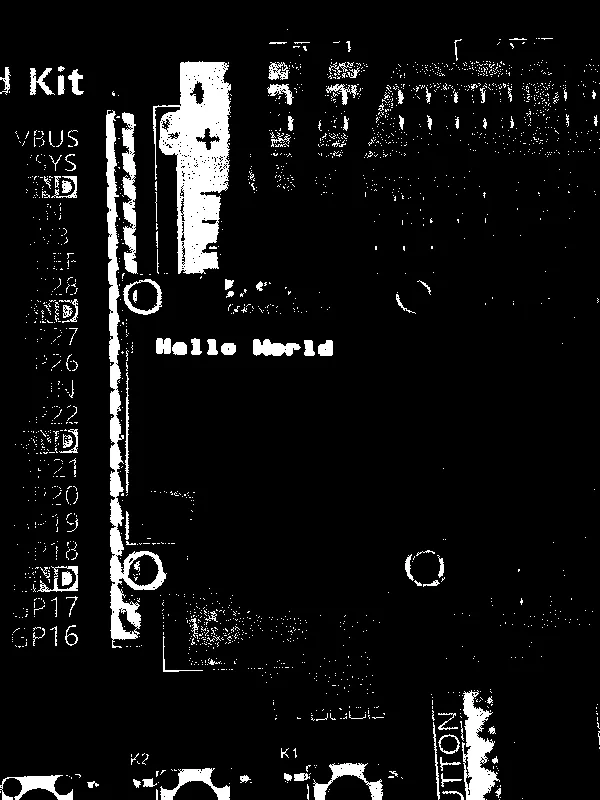 An OLED display module on a breadboard displaying the text "Hello World"