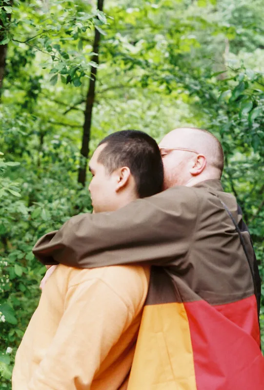 nick hugging erik from behind in the woods