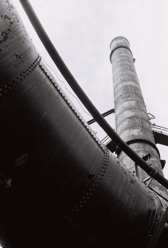 metal tower jutting into sky, mostly obscured by underside of a pipe