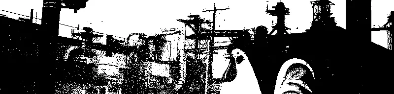 a chicken statue in front of an industrial landscape