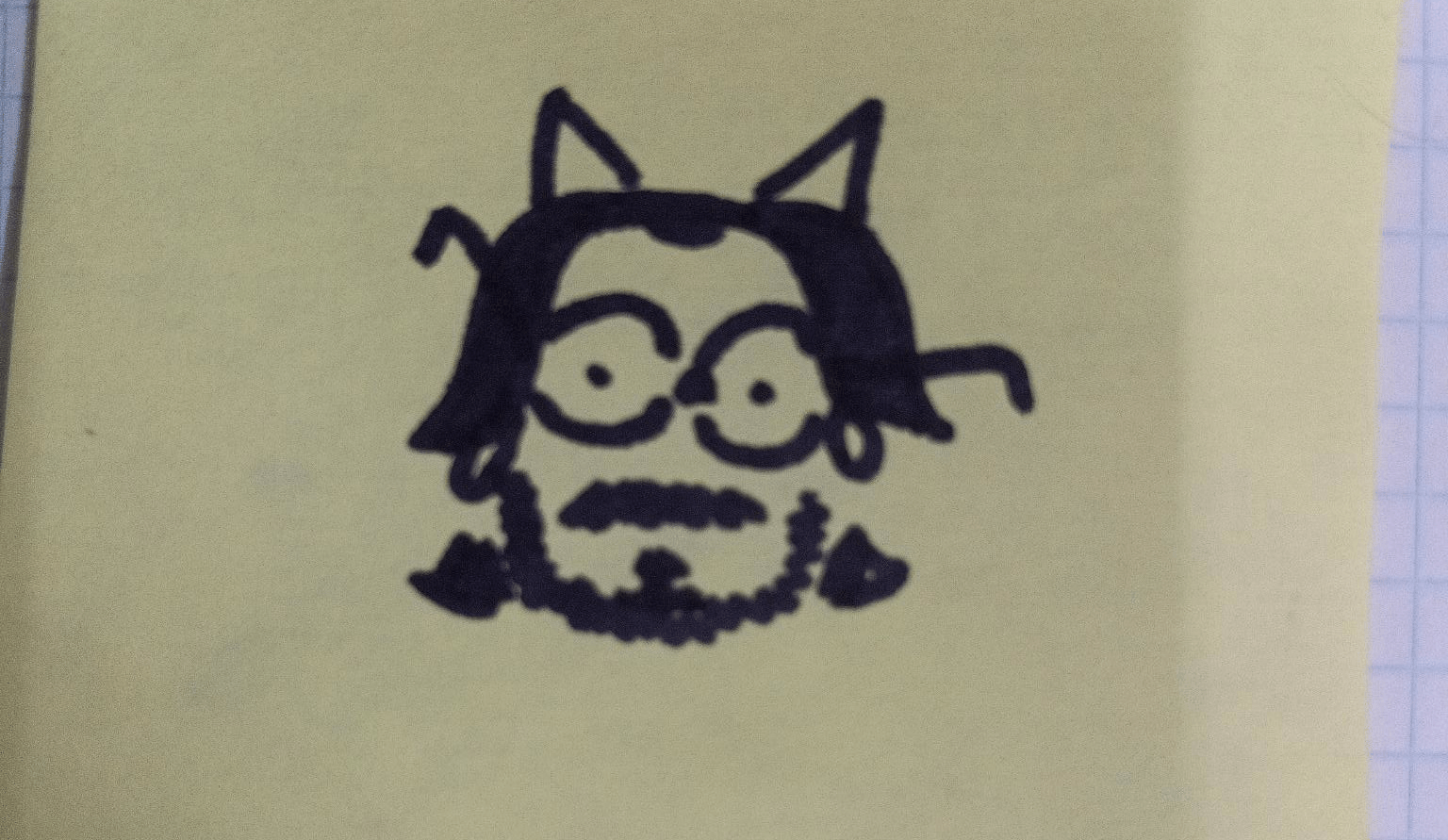 sharpie doodle of a bespectacled balding guy with a beard and triangles coming from his head that could be horns or cat ears