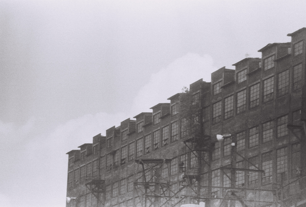 a warehouse with fire escapes and electric poles