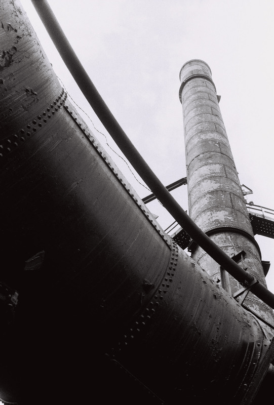 metal tower jutting into sky, mostly obscured by underside of a pipe